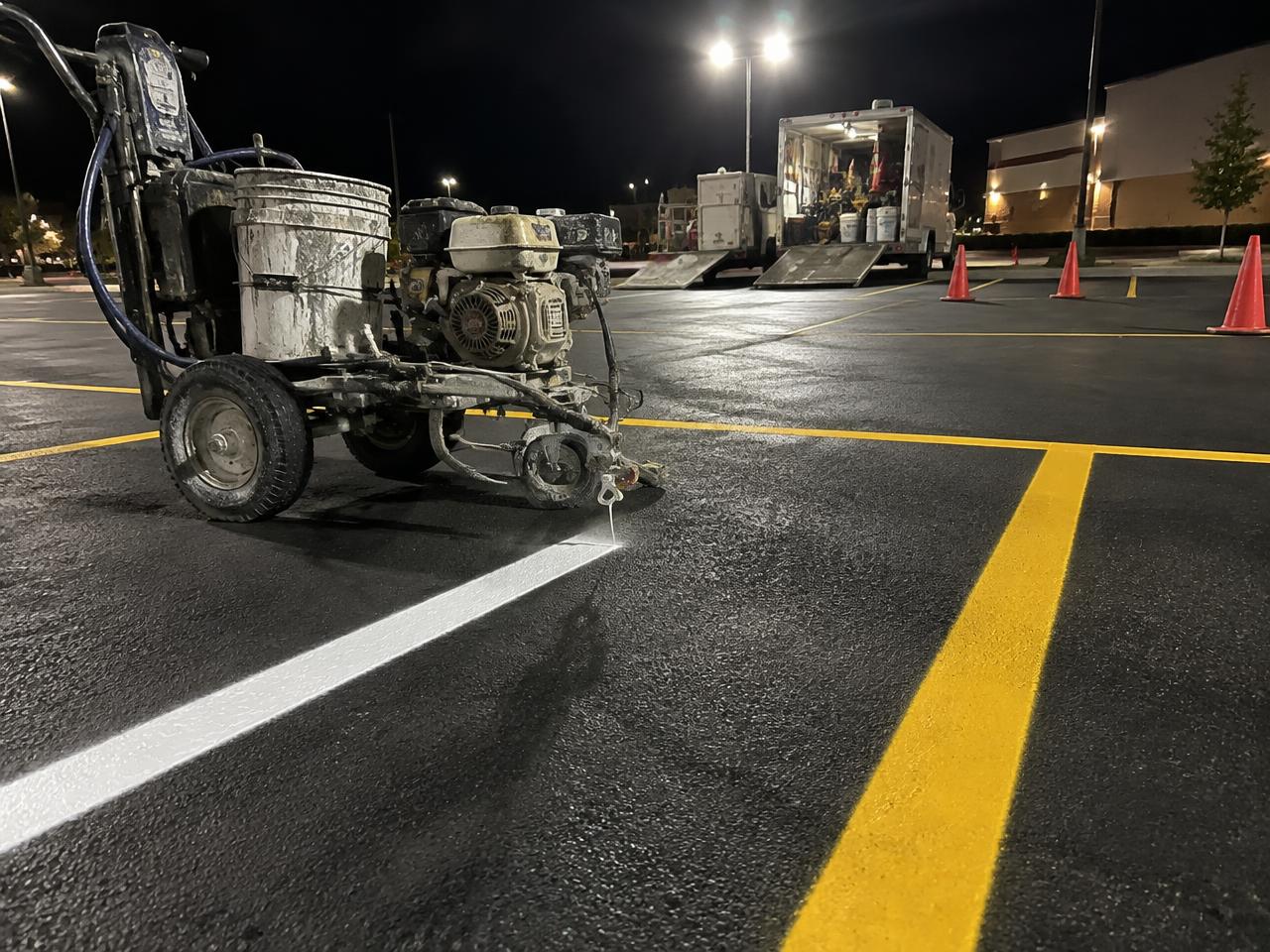 Parking lot line striping equipment working under lights at night